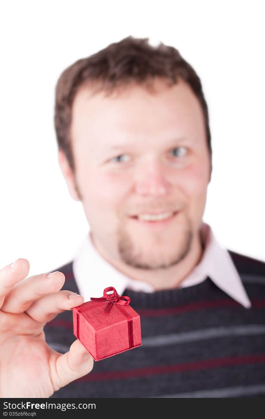 Young man holding valentine gift in his hand. He is giving it somebody. Isolated on white.