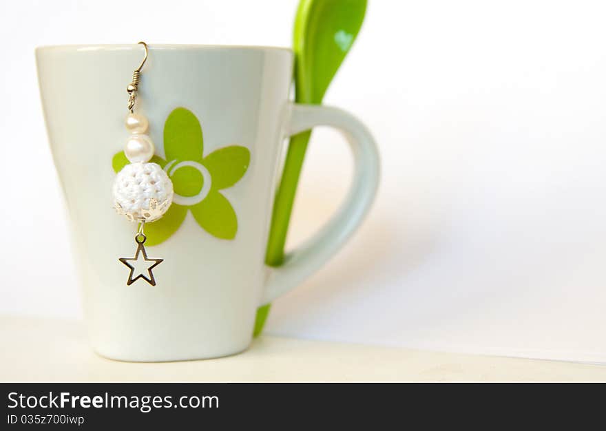 White crocheted earring on white cup