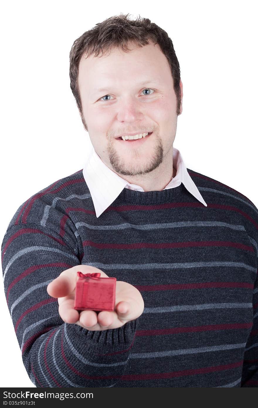 Young man holding valentine gift in his hand. He is giving it somebody. Isolated on white.