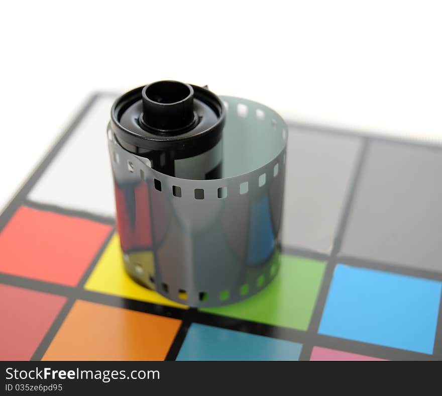 Roll of 35mm Film on top of color calibrated card of squares. Roll of 35mm Film on top of color calibrated card of squares.