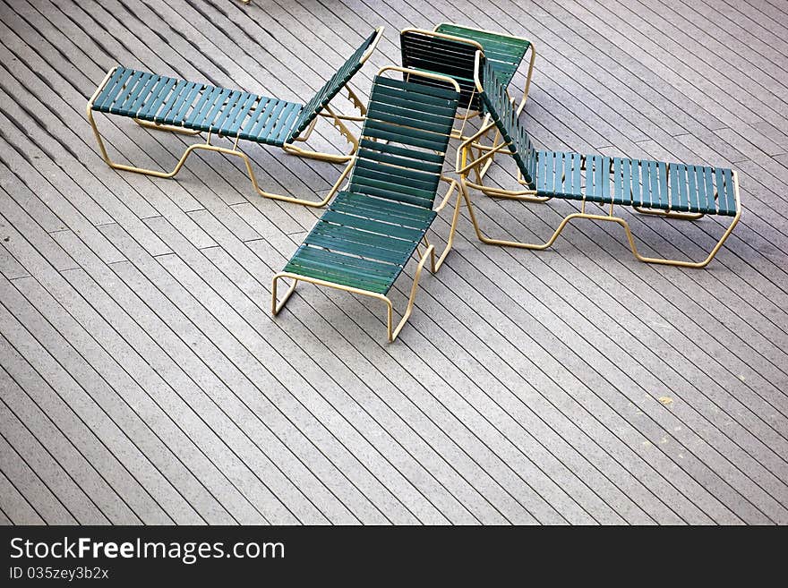 Four back to back lounge chairs on a deck. Four back to back lounge chairs on a deck