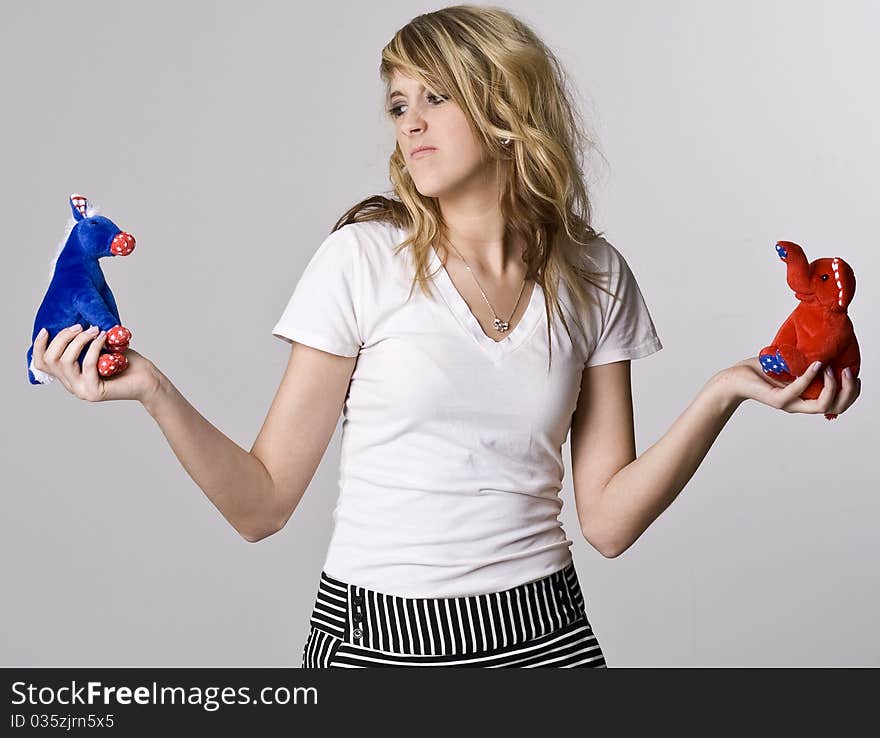 A blonde girl wonders about voting for Republicans or Democrats. A blonde girl wonders about voting for Republicans or Democrats