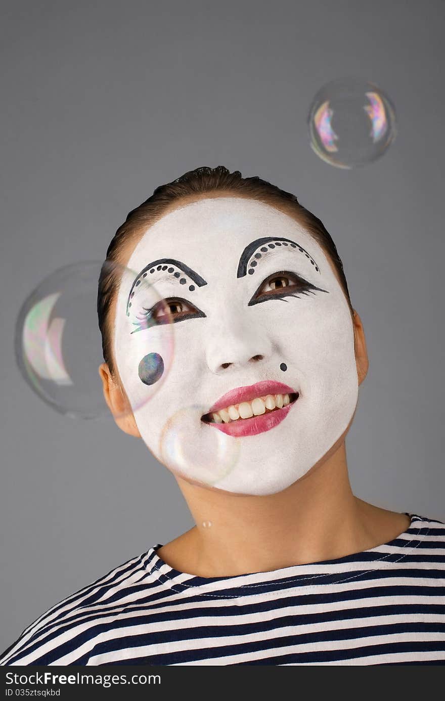 Smiling mime portrait with bubbles on grey background. Smiling mime portrait with bubbles on grey background