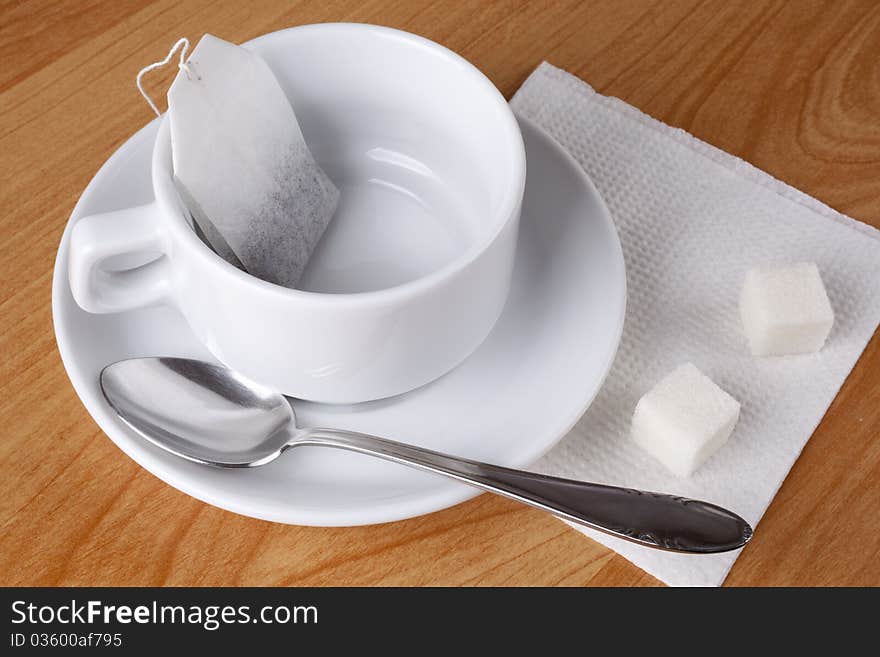 Cup for tea, sugar and spoon on table