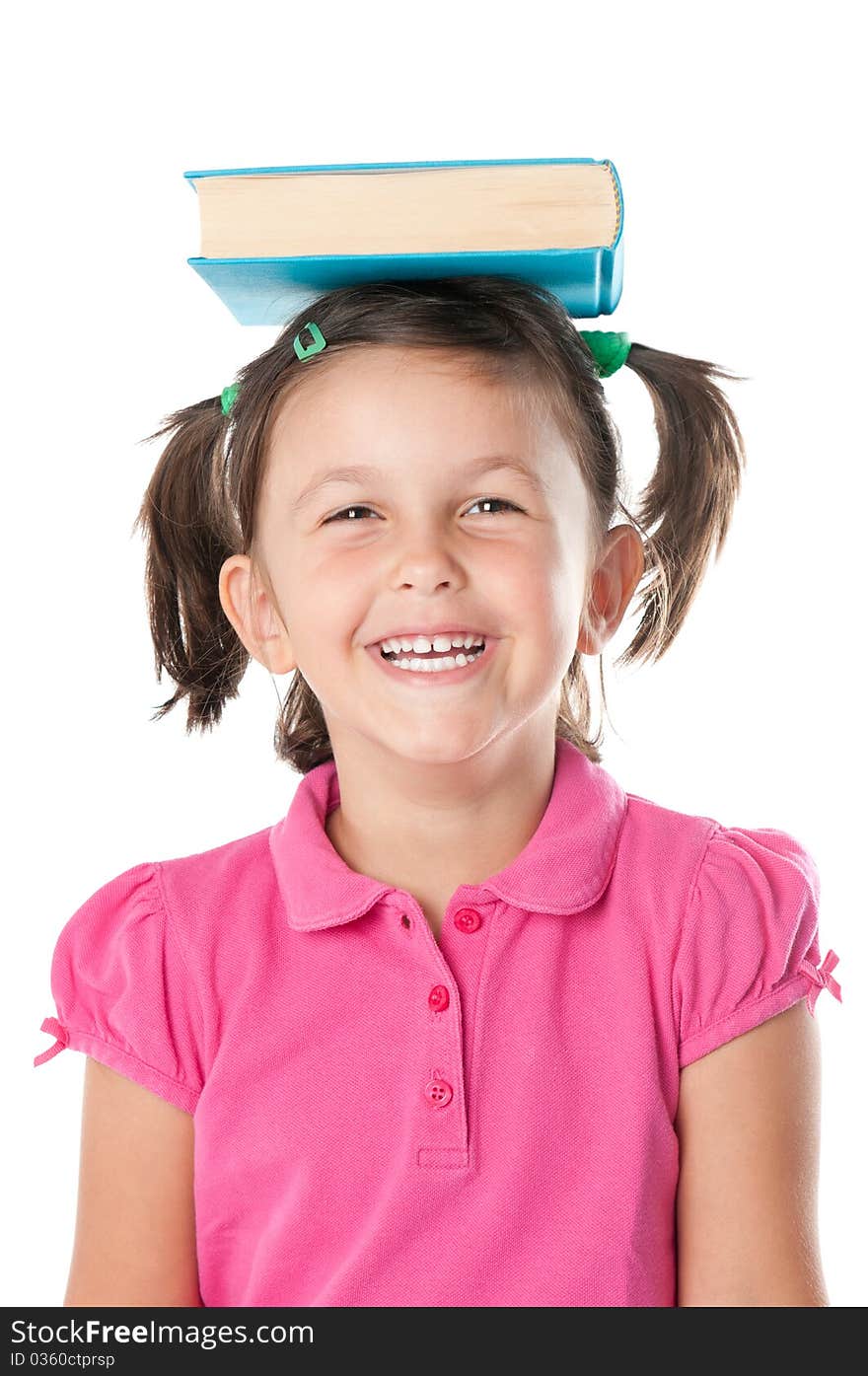 Happy smiling little girl carrying a book on her head isolated on white background. Happy smiling little girl carrying a book on her head isolated on white background