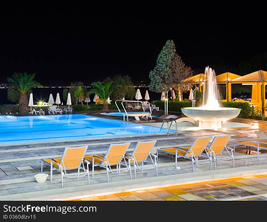 Water pool and fountain at night - vacation background