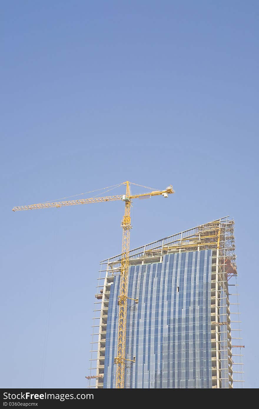 Crane constructing a glass buildling. Crane constructing a glass buildling