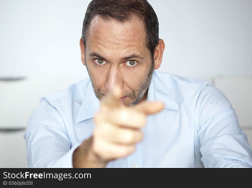 Mature well dressed businessman is pointing into the camera. Mature well dressed businessman is pointing into the camera