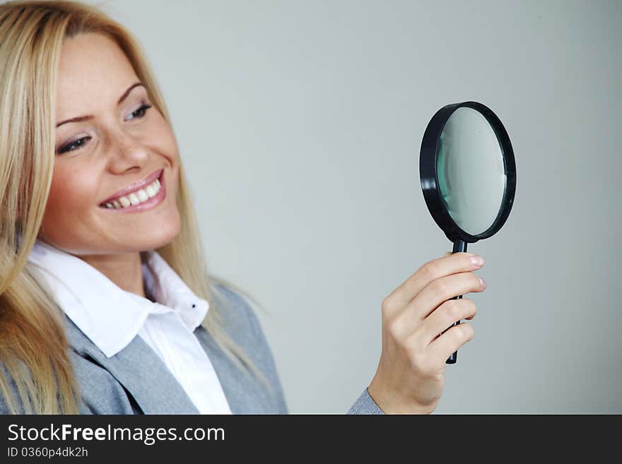 Business woman looking through a magnifying glass