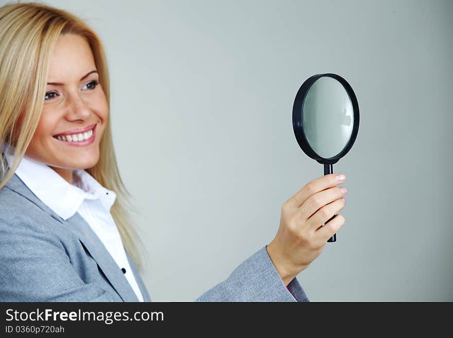 Business woman looking through a magnifying glass