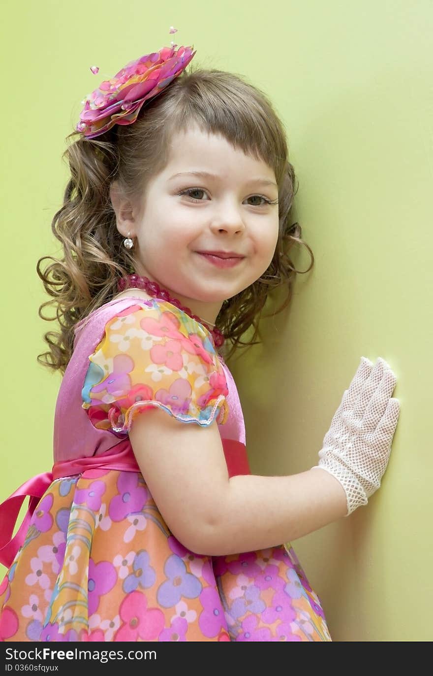 The elegant girl in a dress and gloves costs near a wall. The elegant girl in a dress and gloves costs near a wall