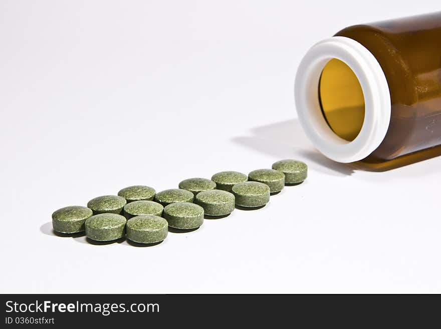 Vitamin pills with a bottle, on a white background