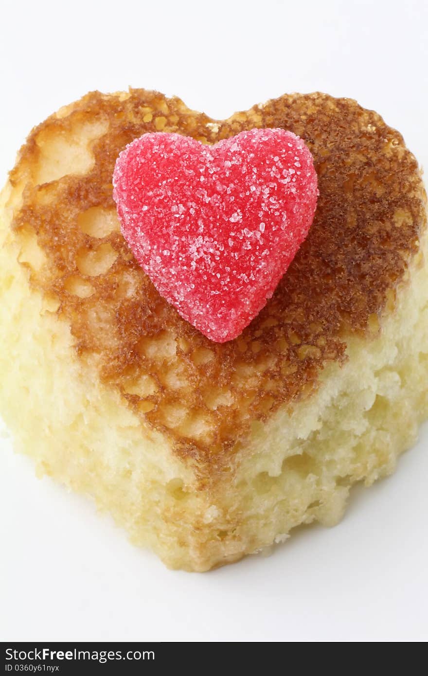 Heart shaped vanilla cupcake topped with a red heart jelly candy. Heart shaped vanilla cupcake topped with a red heart jelly candy