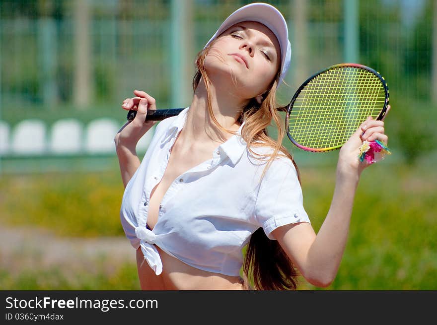 Beautiful girl on a tennis court on a background dark blue sky. Beautiful girl on a tennis court on a background dark blue sky