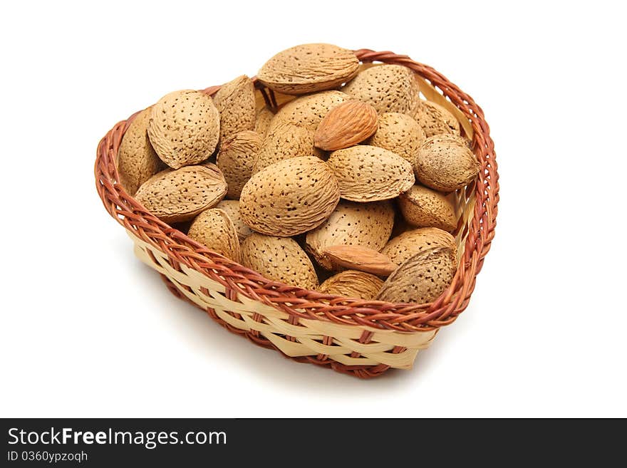 Tasty almond nuts in in wicker bowl  isolated on white. Tasty almond nuts in in wicker bowl  isolated on white