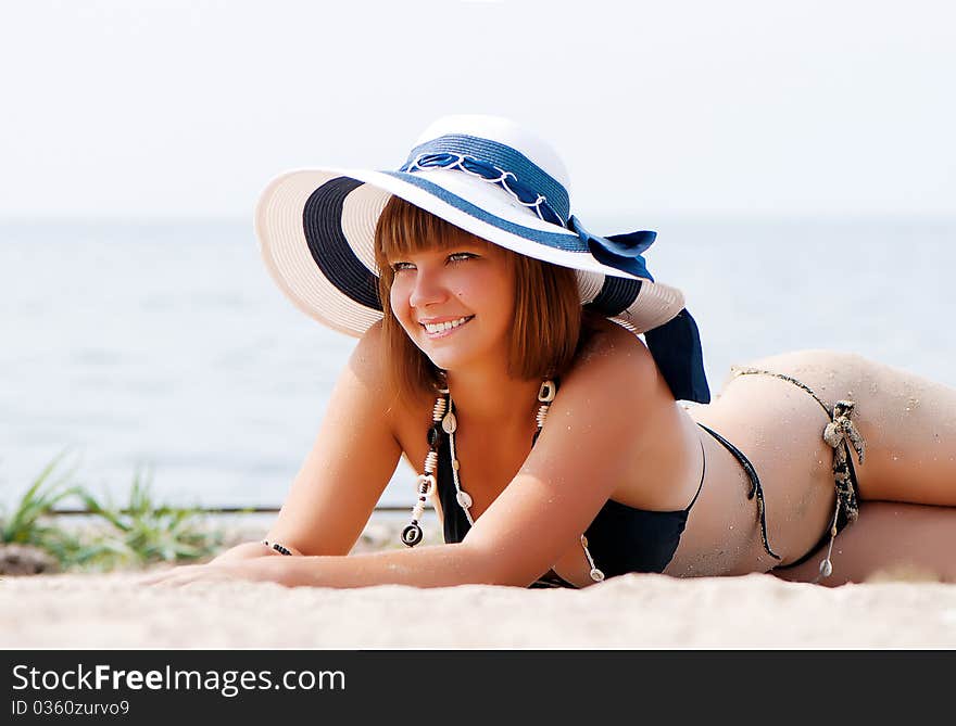 Young Woman Enjoying The Sun Laying On A Beach