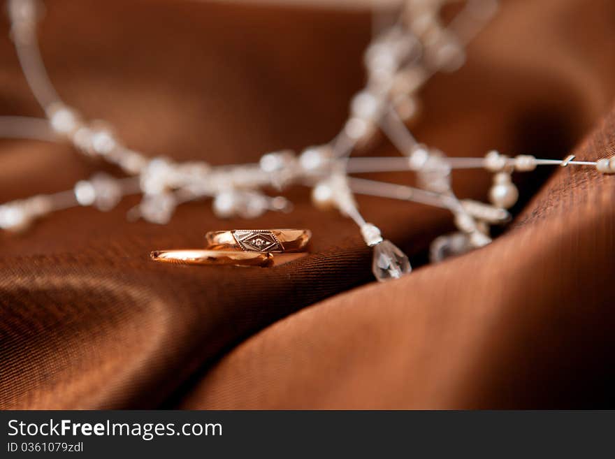 Two wedding rings and pearl collar on the cloth