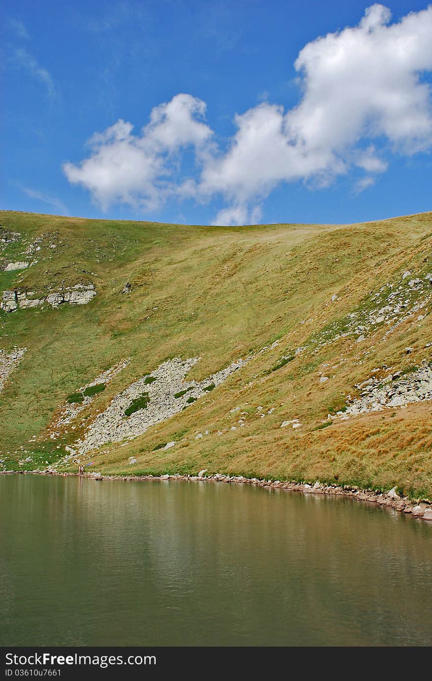 Mountain lake with abrupt coast in a summer bright landscape