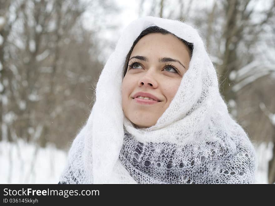 The young happy woman in a white knitted scarf lau