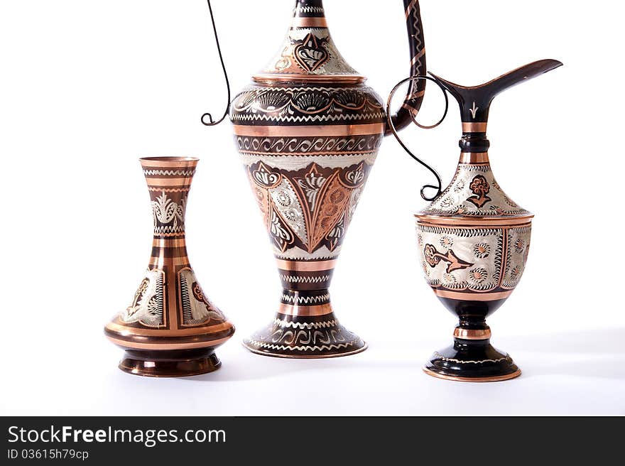 Copper jug with a traditional Arabic ornaments on a white background