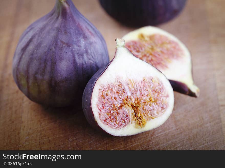 Four fresh figs on the wooden background