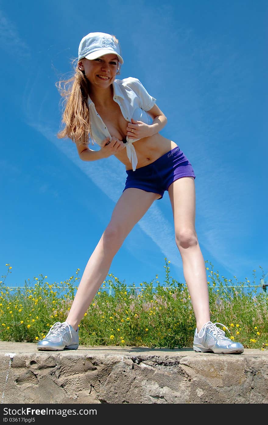 Beautiful girl on a tennis court on a background dark blue sky. Beautiful girl on a tennis court on a background dark blue sky