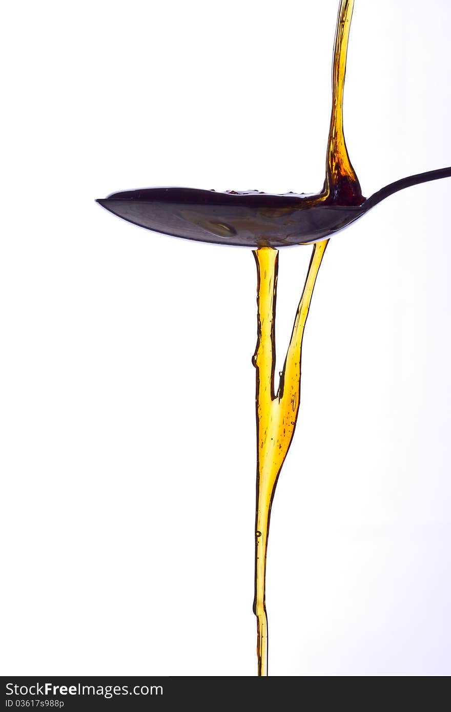 An inviting spoonful of syrup being poured out.