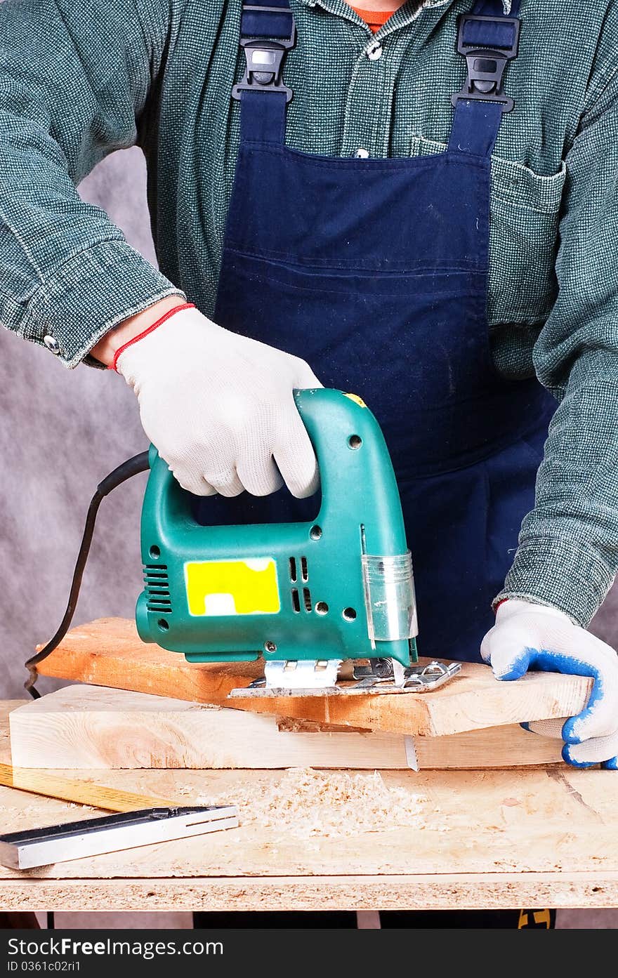 The working carpenter with a fret saw for work on a tree. The working carpenter with a fret saw for work on a tree