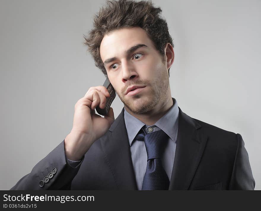 Businessman with worried expression using a mobile phone. Businessman with worried expression using a mobile phone