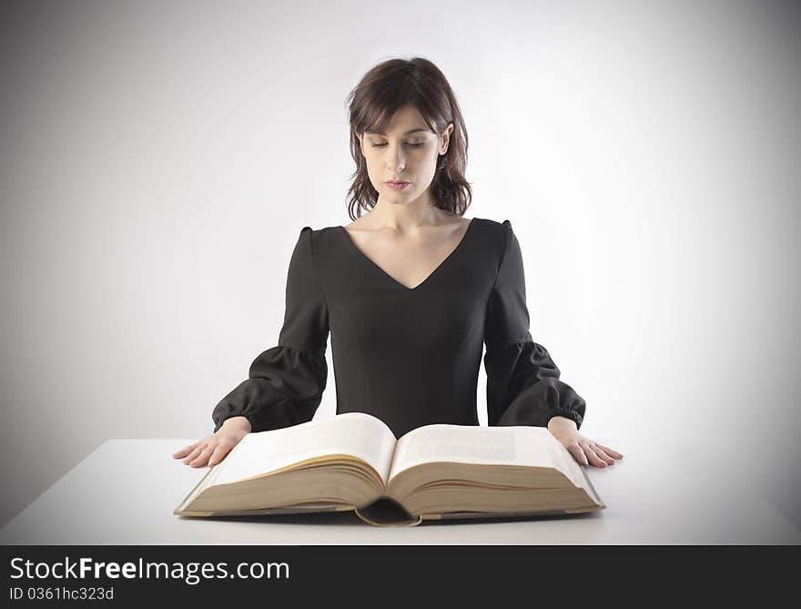 Young woman reading a thick book. Young woman reading a thick book