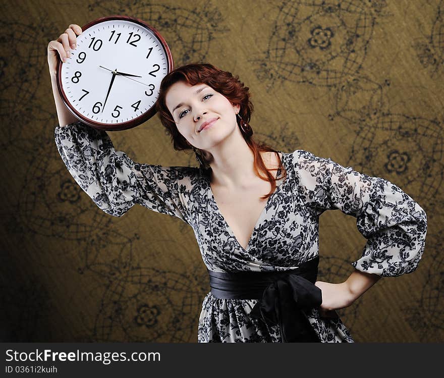 An image of a nice woman with a big clock. An image of a nice woman with a big clock