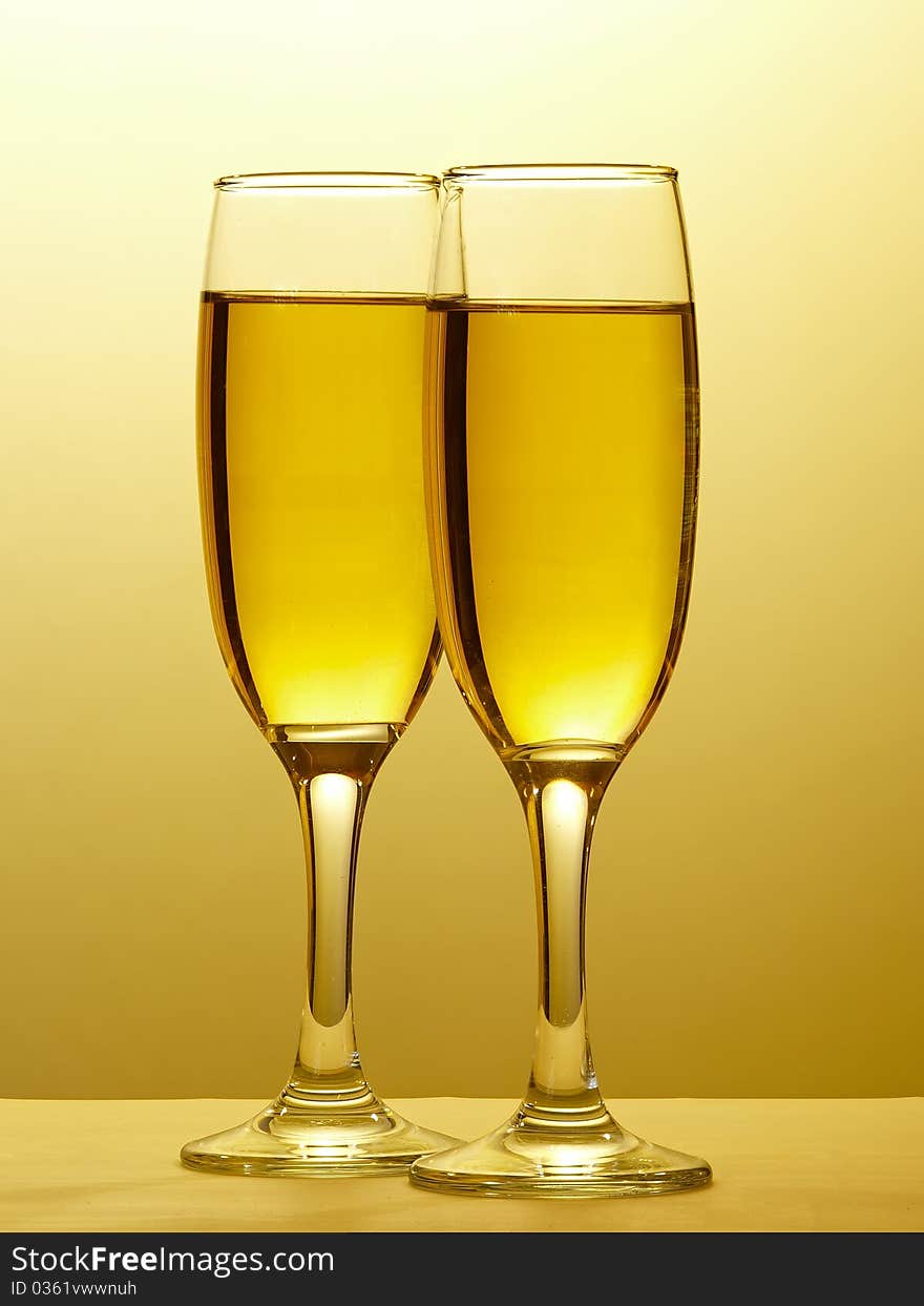 Sparkling wine in two glasses clinked in toast to celebrate event. Isolated on white. Sparkling wine in two glasses clinked in toast to celebrate event. Isolated on white.