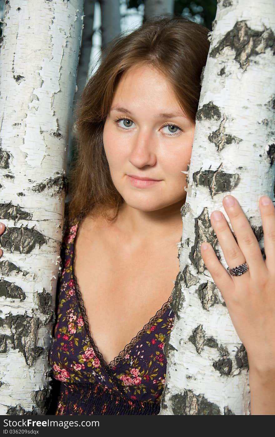 Attractive young tired woman near by birch