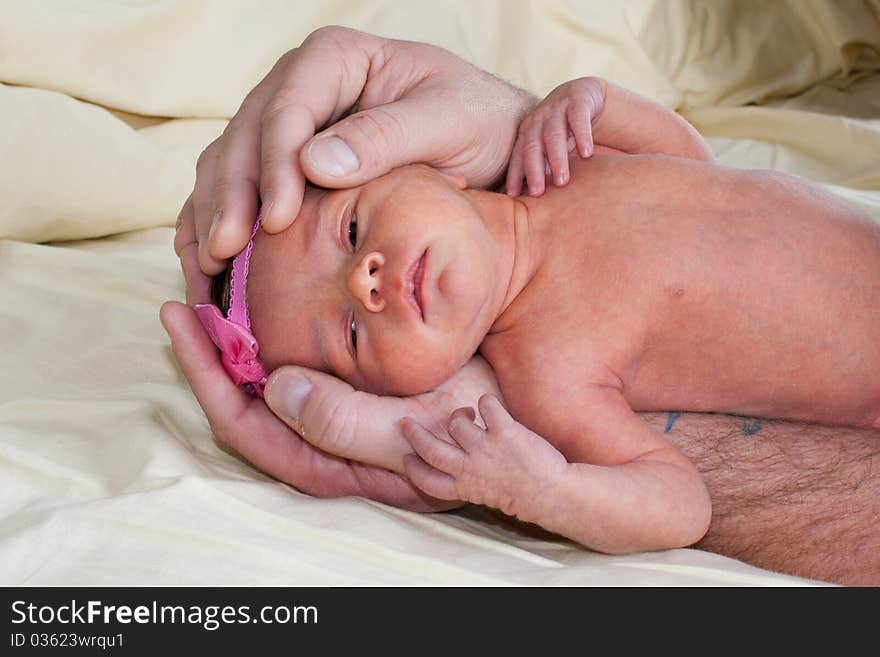 A cute little baby laying down with a pink bow. A cute little baby laying down with a pink bow.