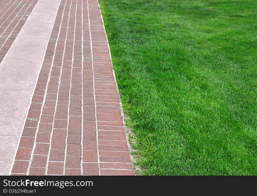 Brick pathway along green grass - background