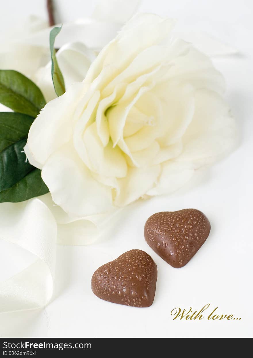 Two chocolate hearts with white flower on background. With simple text. Two chocolate hearts with white flower on background. With simple text