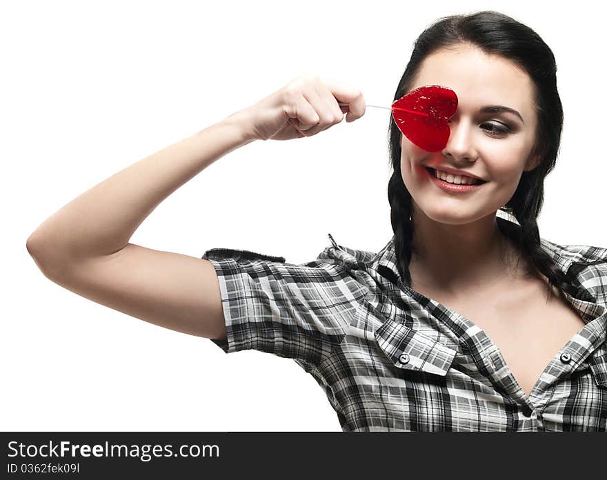 Young smiling girl with red heart lolipop isolated on white