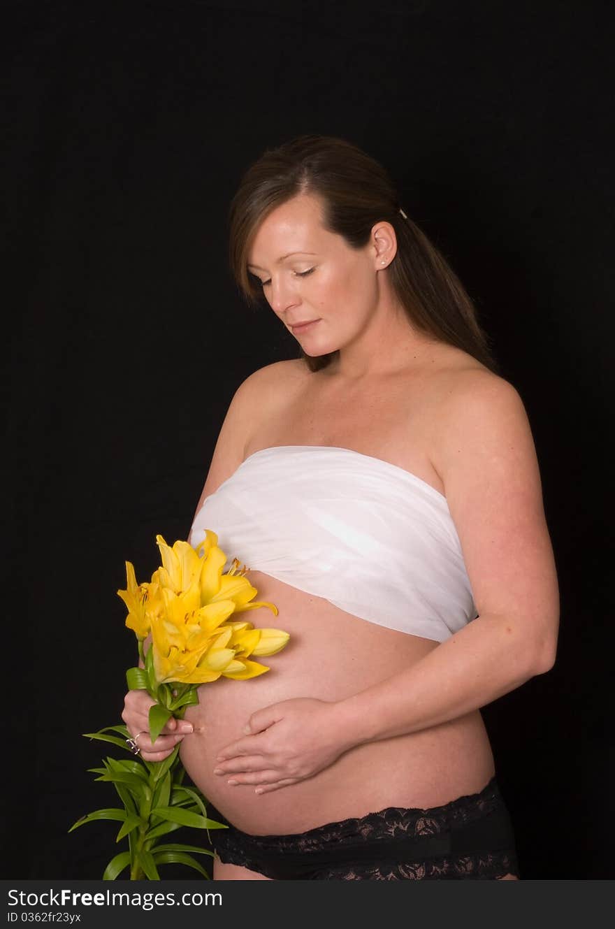 Pregnant lady with yellow flowers and black background. Pregnant lady with yellow flowers and black background