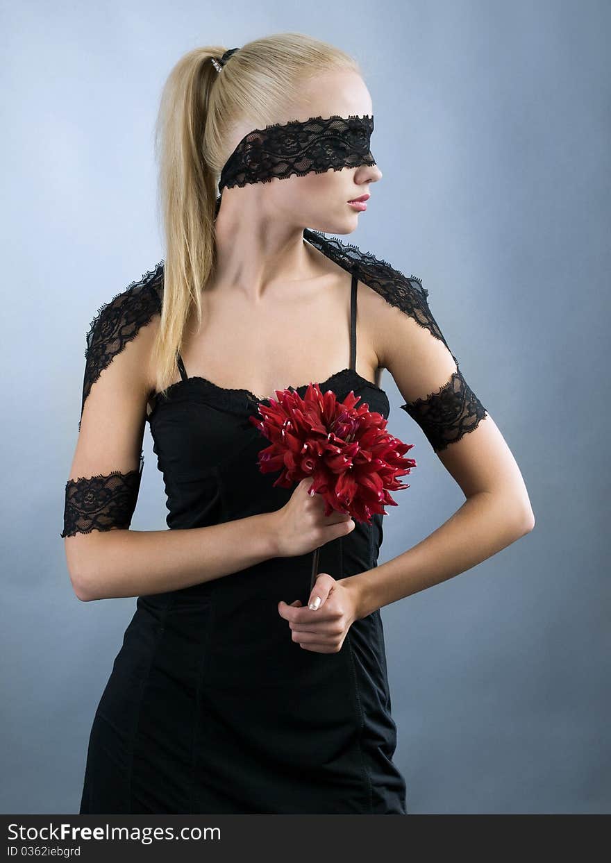 Emotional blonde girl with closed eyes and red flower at hand. Emotional blonde girl with closed eyes and red flower at hand