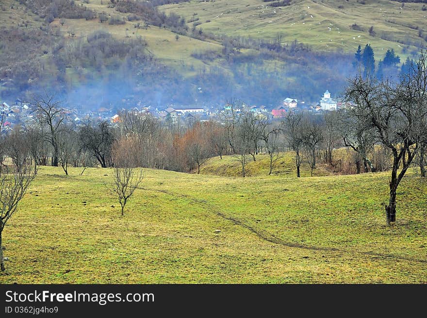 Fog over valley village with orchard