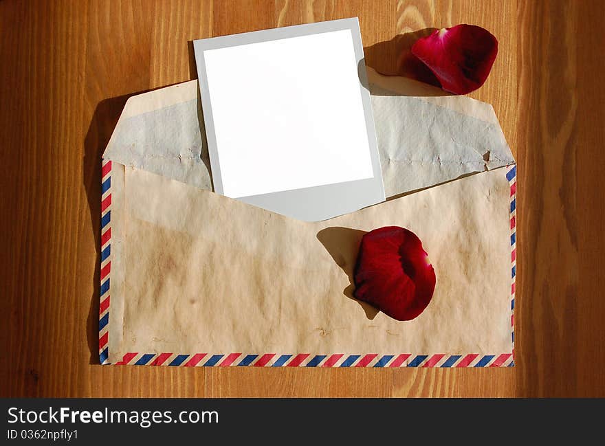 Love letter with rose petals and a blank photograph. Love letter with rose petals and a blank photograph