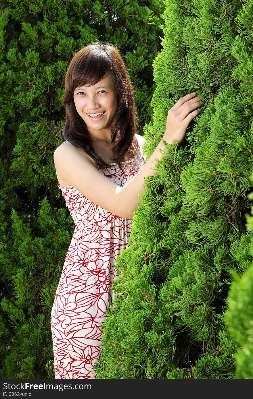 Young beautiful girl smiling outdoor near pine tree. Young beautiful girl smiling outdoor near pine tree