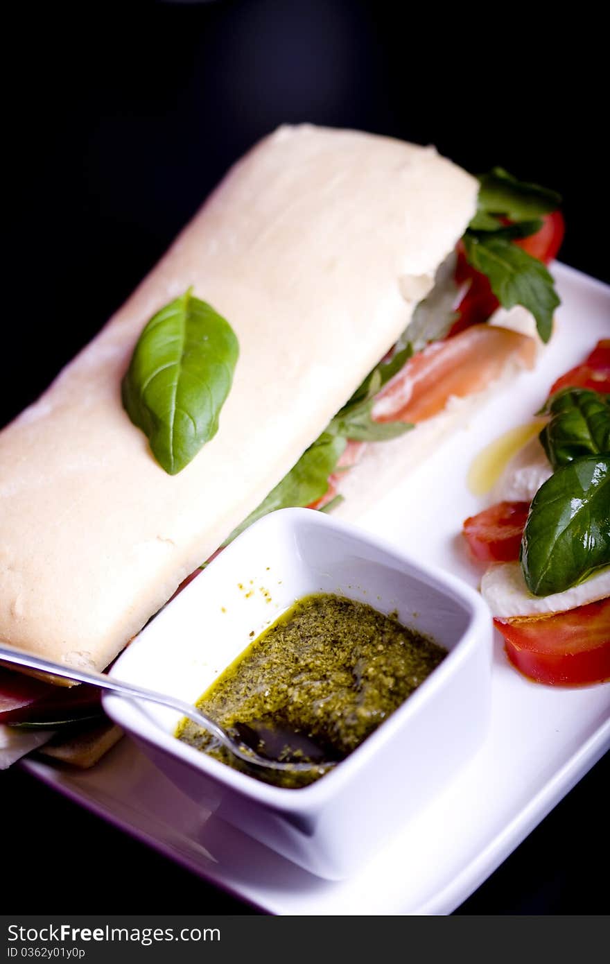 Long baguette sandwich with ham, fresh vegetables and pesto. Long baguette sandwich with ham, fresh vegetables and pesto