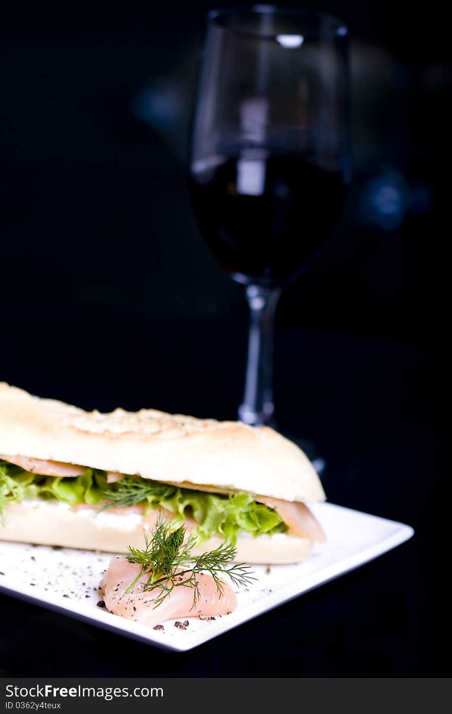 Long baguette sandwich with salmon and fresh vegetables. Long baguette sandwich with salmon and fresh vegetables