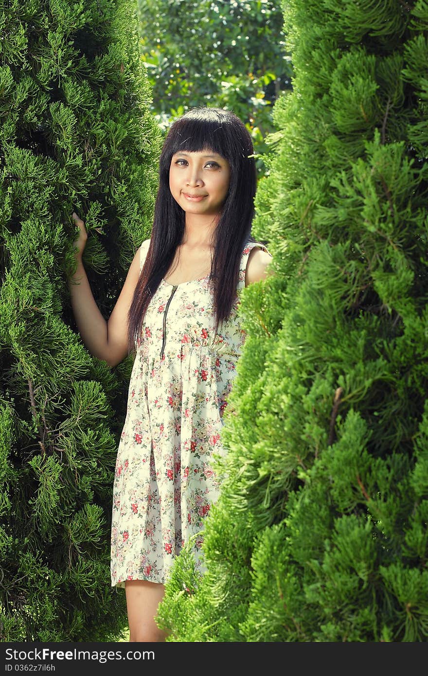 Young beautiful girl wearing dress smiling outdoor near pine tree. Young beautiful girl wearing dress smiling outdoor near pine tree