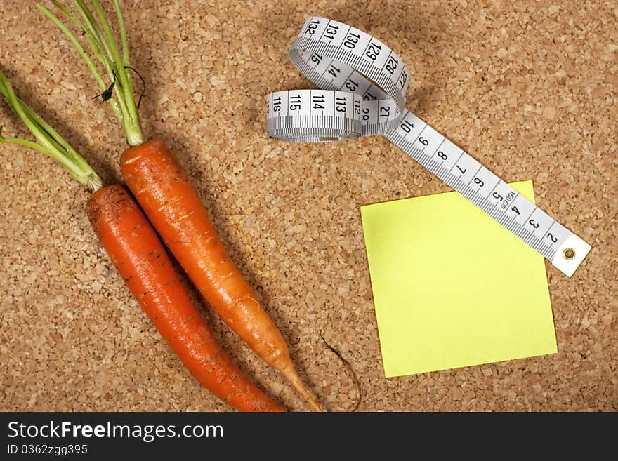 Yellow sticky note to self reminding to lose weight with measuring tape and carrots. Yellow sticky note to self reminding to lose weight with measuring tape and carrots