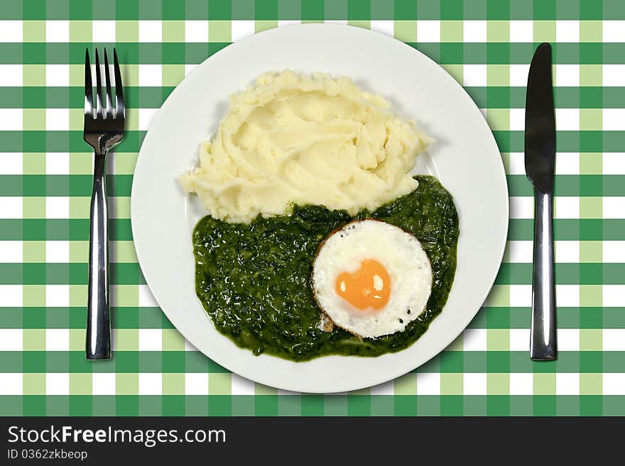 Spinach with egg and mashed potatoes and cutlery