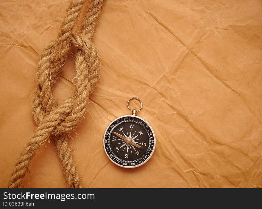 Compass and rope on old yellow paper. Compass and rope on old yellow paper