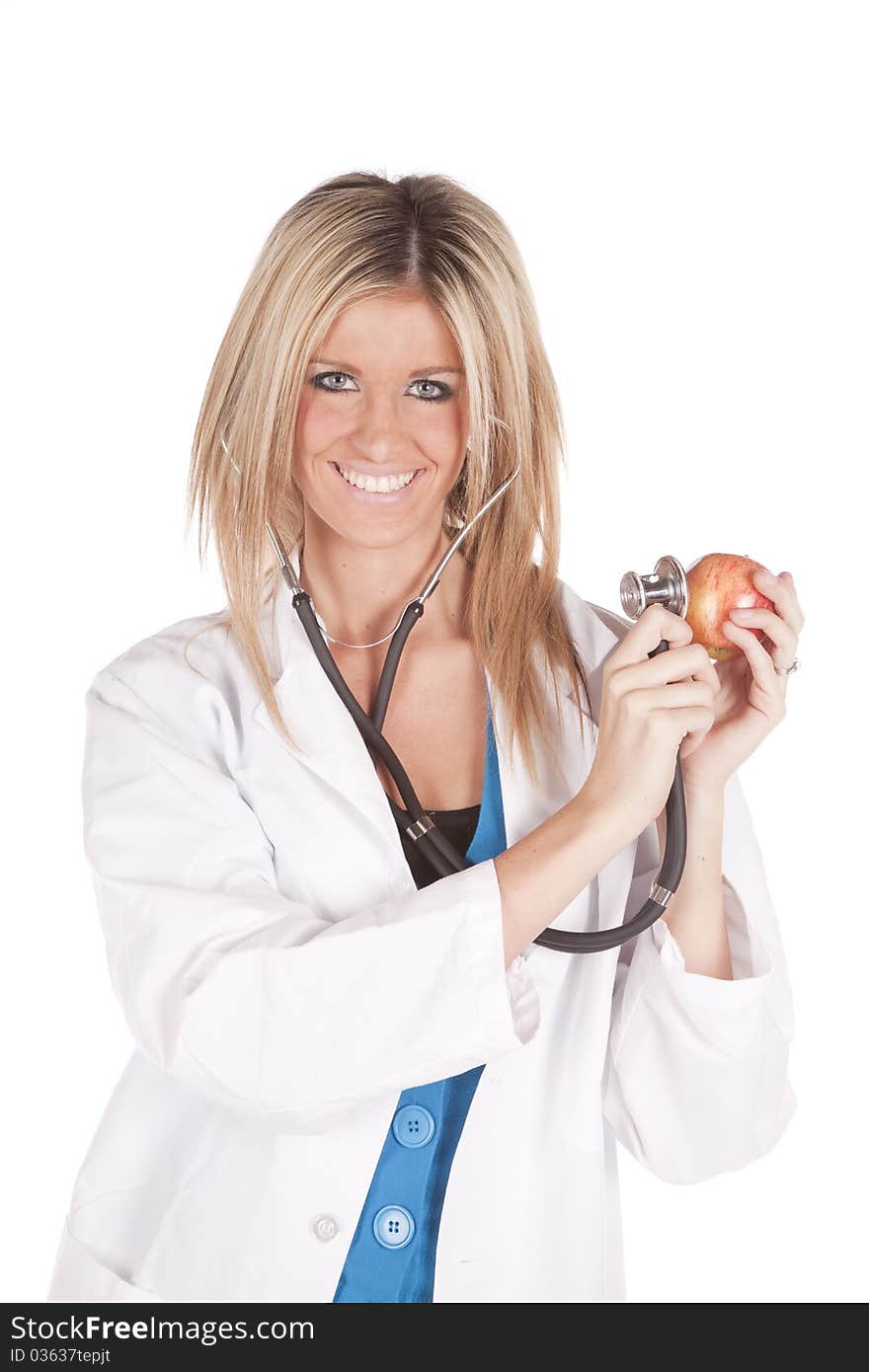 A woman doctor is holding a stethoscope to an apple. A woman doctor is holding a stethoscope to an apple.