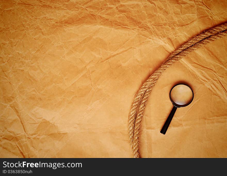 Magnifying glass and rope on old paper